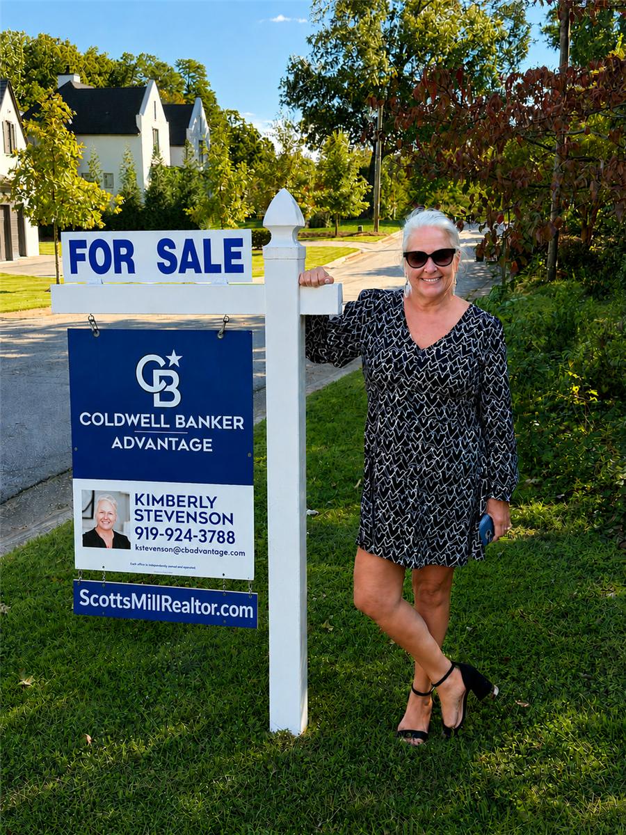 Kimberly Stevenson beside a For Sale sign in Scotts Mill
